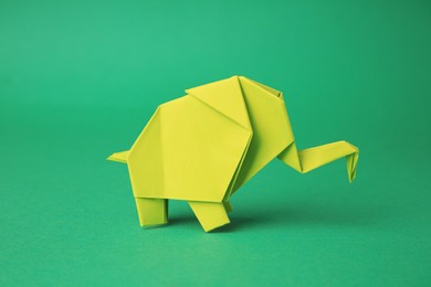 Photo of Origami art. Paper elephant on green background