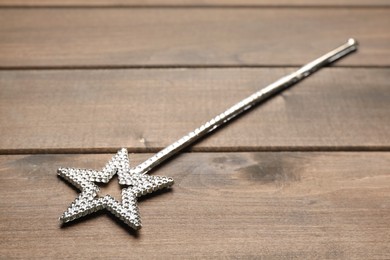 Beautiful silver magic wand on wooden table