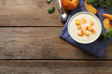 Delicious yogurt with fresh peach on wooden table, flat lay. Space for text