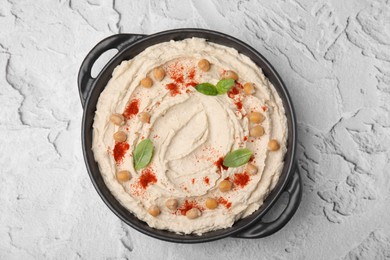 Delicious hummus with chickpeas and paprika on white textured table, top view