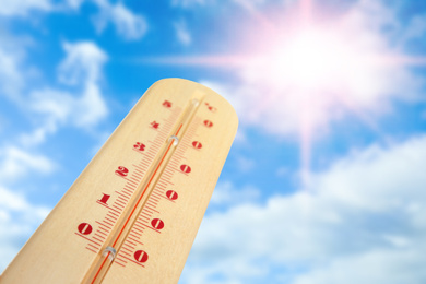 Image of Weather thermometer with high temperature and beautiful sky on background, space for text 