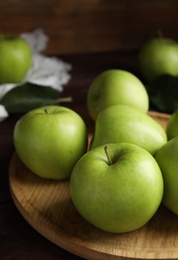 Fresh ripe green apples on wooden tray, closeup