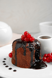 Delicious warm chocolate lava cake with berries on plate, closeup