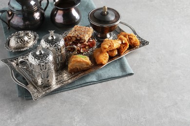 Photo of Tea, baklava dessert and Turkish delight served in vintage tea set on grey textured table