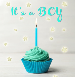 Image of Baby shower cupcake with candle for boy on light table