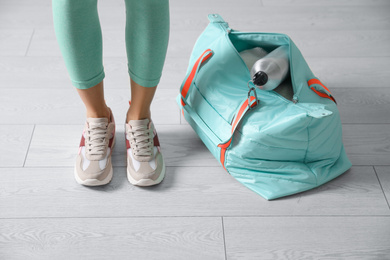 Woman with sportive bag on wooden floor, closeup