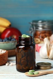 Bottle of pills and foodstuff on white wooden table. Prebiotic supplements