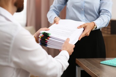 Photo of Woman giving documents to colleague in office, closeup