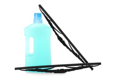 Bottle of windshield washer fluid and wipers on white background