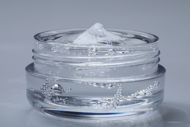 Jar of transparent cosmetic gel on light background