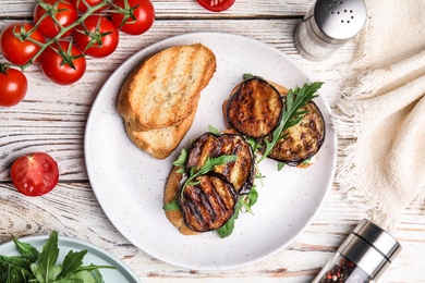 Delicious eggplant sandwiches served on white wooden table, flat lay