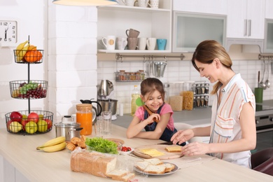 Housewife with her daughter preparing dinner on kitchen