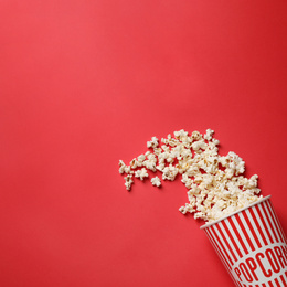 Delicious popcorn on red background, top view. Space for text