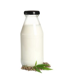 Glass bottle of hemp milk, leaf and seeds on white background