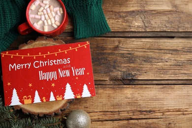 Flat lay composition with greeting card on wooden background, space for text. Christmas celebration