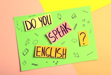 Note with question Do You Speak English on color background, top view