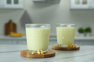 Photo of Tasty fresh corn milk in glasses on white table indoors