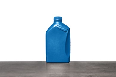 Motor oil in blue container on grey table against white background