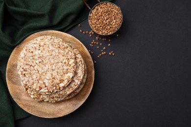 Crunchy buckwheat cakes and cereal on black table, flat lay. Space for text