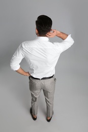 Photo of Businessman in formal clothes on grey background, back view