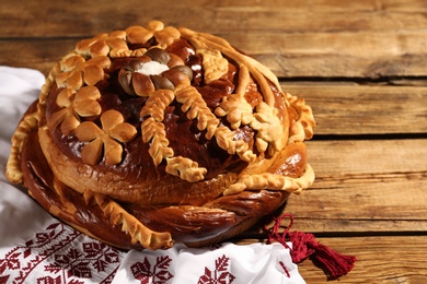 Korovai with rushnyk on wooden table. Ukrainian bread and salt welcoming tradition