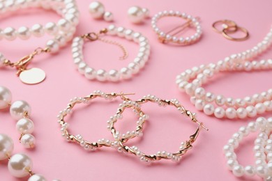 Photo of Elegant pearl jewelry on pink background, closeup