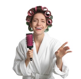 Beautiful young woman in bathrobe with hair curlers singing into hairbrush on white background