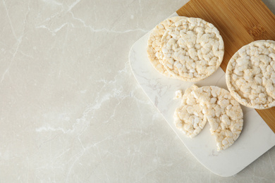 Puffed rice cakes on grey marble table, top view. Space for text