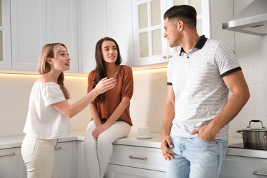 Group of people having conversation in kitchen
