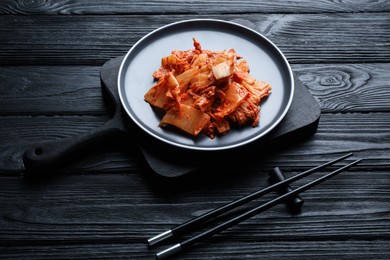 Delicious kimchi with Chinese cabbage served on black wooden table