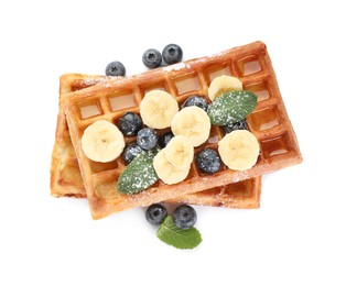 Photo of Delicious Belgian waffles with blueberries and banana on white background, top view