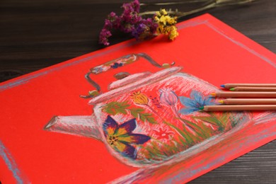 Colorful pastel pencils, flowers and beautiful painting on wooden table