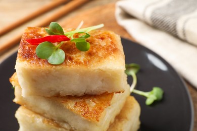 Delicious turnip cake with microgreens on table, closeup