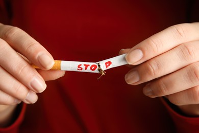 Photo of Woman breaking cigarette, closeup. Quitting smoking concept