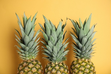 Photo of Fresh ripe juicy pineapples on orange background