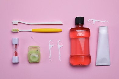 Flat lay composition with tongue cleaners and teeth care products on pink background