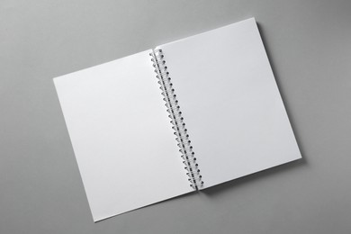 Open blank notebook on grey background, top view. Mockup for design