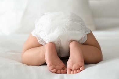 Cute little baby in diaper on bed