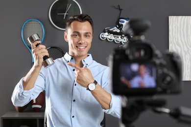 Sport blogger recording video on camera indoors