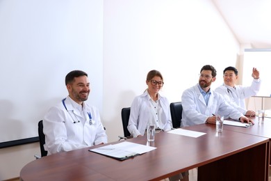 Photo of Doctors at table in meeting room during medical conference