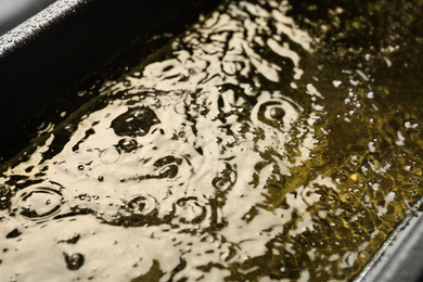Photo of Hot cooking oil in deep fryer, closeup