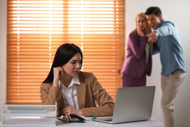 Coworkers bullying their colleague at workplace in office