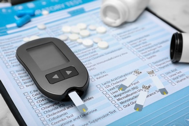 Digital glucometer and medicine on form for laboratory test. Diabetes concept