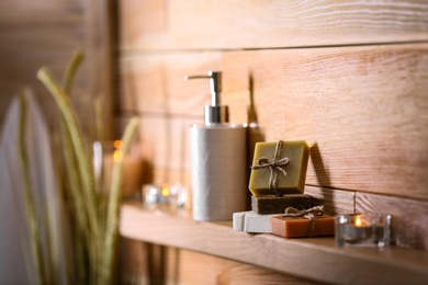 Soap bars and toiletries on wooden shelf. Space for text