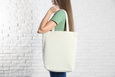 Woman with eco bag near brick wall. Mock up for design