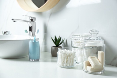 Cotton swabs and soap bars on white countertop in bathroom