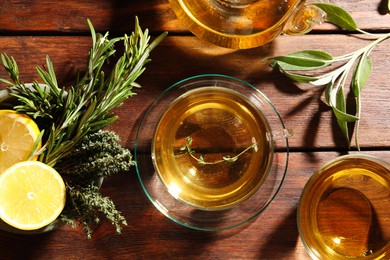 Photo of Aromatic herbal tea, fresh rosemary, thyme and lemon on wooden table, flat lay