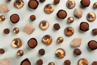 Different delicious chocolate candies on light background, flat lay