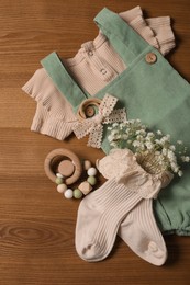 Children's clothes and toy on wooden table, flat lay