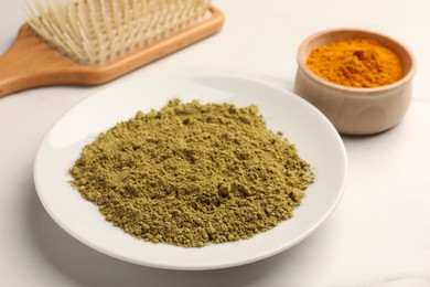 Photo of Henna, turmeric powder and comb on white table. Natural hair coloring